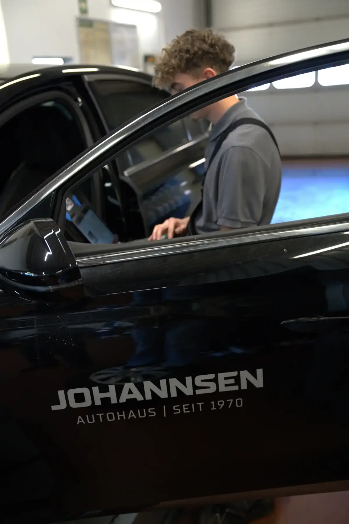 Mechaniker von Autohaus Johannsen an einem Fahrzeug mit Johannsen-Branding