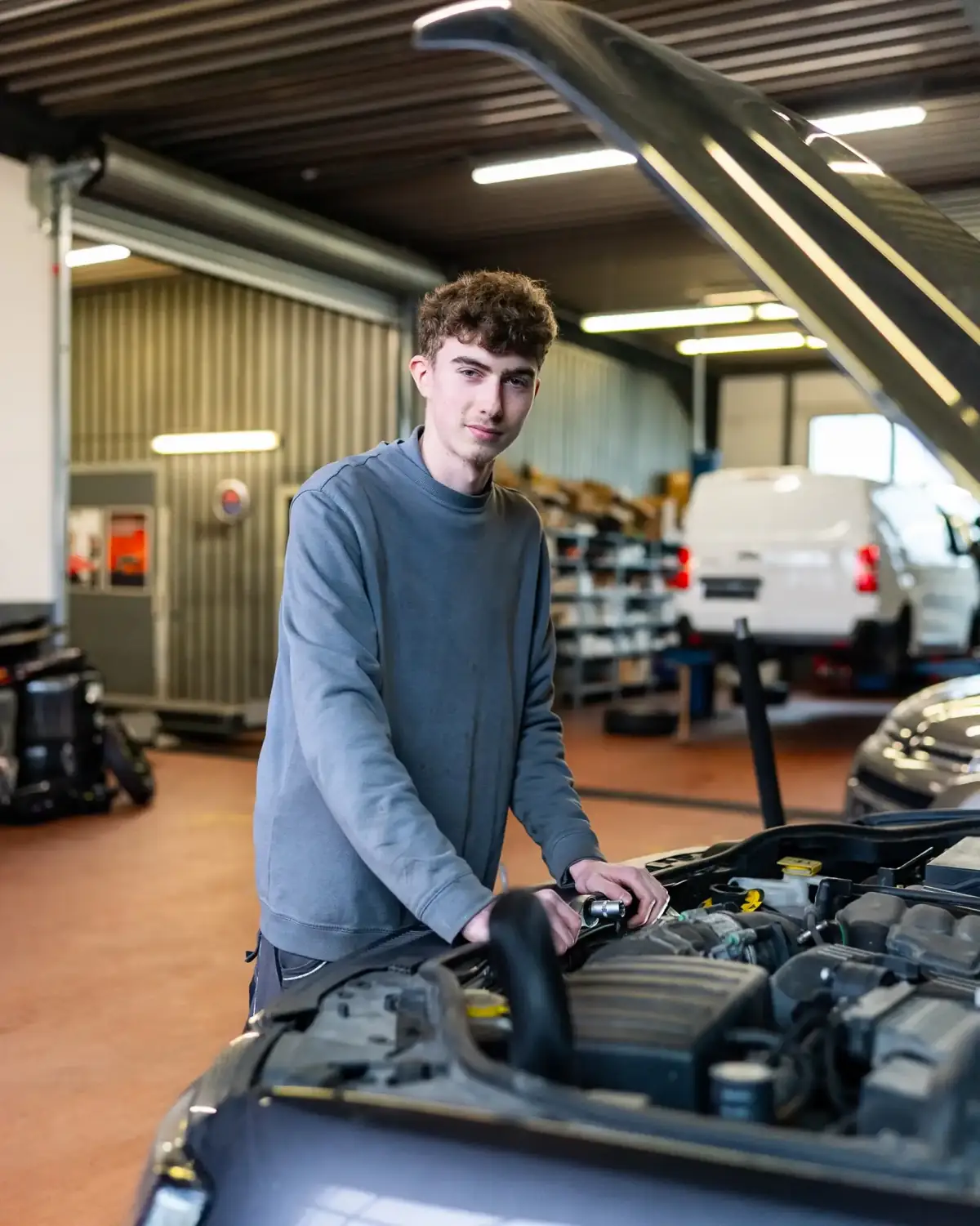 Kfz-Mechatroniker von Autohaus Johannsen am geöffneten Motorraum