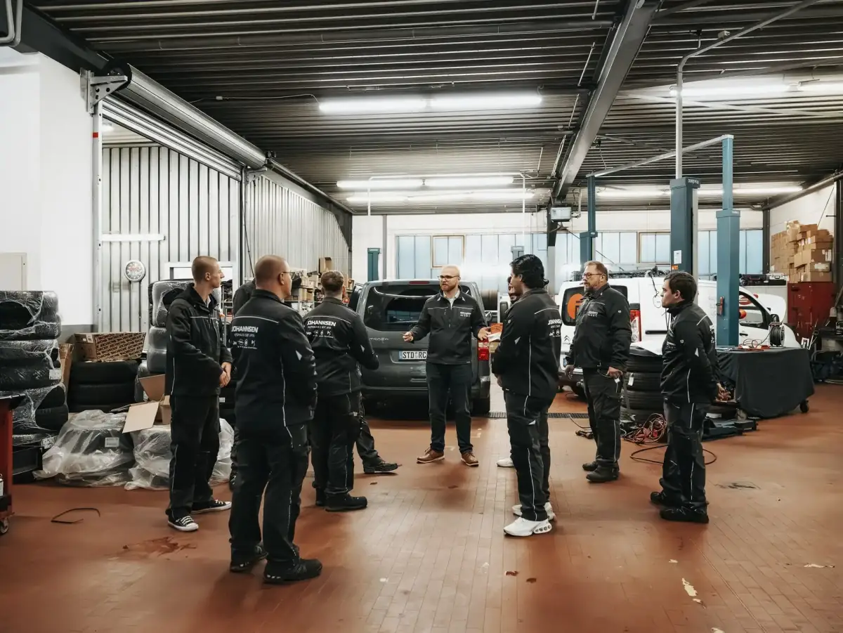 Mitarbeiter von Autohaus Johannsen im Gespräch in der Werkstatthalle